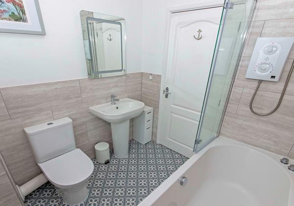 Family bathroom with bath shower over, wc and washbasin