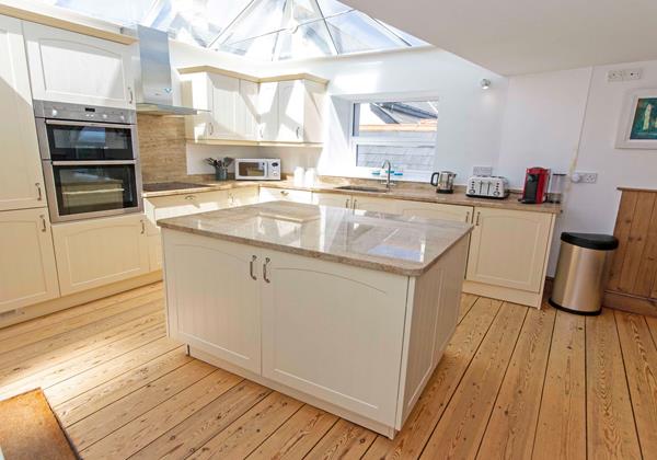 Kitchen cooking with a glass vaulted ceiling star gazing from indoors