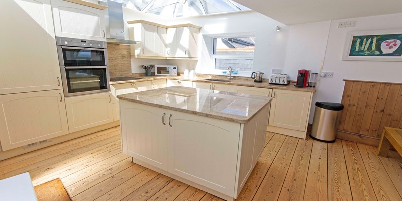 Kitchen cooking with a glass vaulted ceiling star gazing from indoors