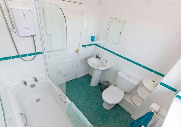 Family bathroom with bath, shower over, washbasin and w.c